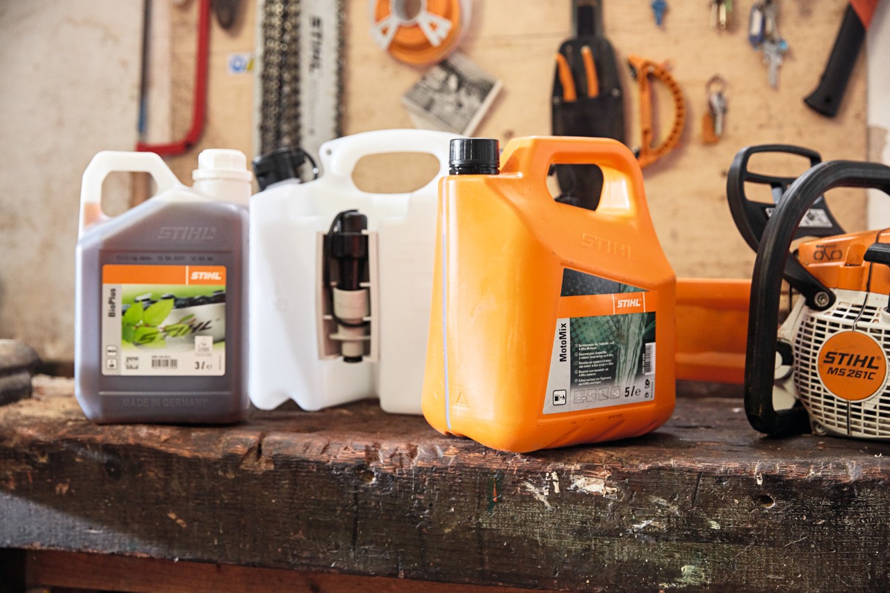 Motosierra de gasolina STIHL MS 261 C-M con espada Light 04 junto a la mezcla de combustible STIHL MotoMix 
