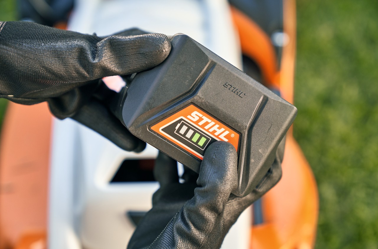 Batería de litio-ión STIHL, en segundo plano un cortacésped de batería STIHL RMA 339 C