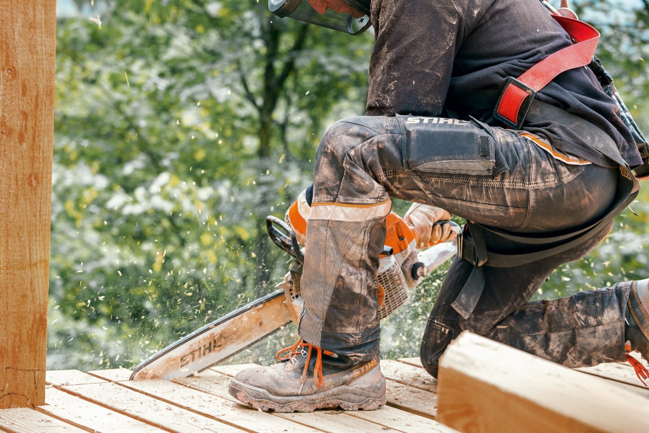 Una persona con protecciones para motosierras, lleva unos pantalones STIHL Advance X-Light y corta con una motosierra.