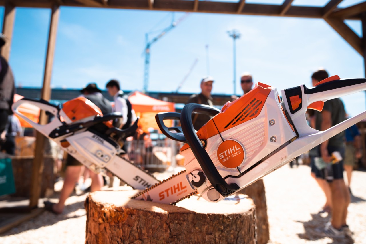 Motosierras STIHL, incluida la MSA 300 C, en un stand de una feria al aire libre.